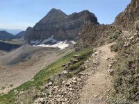 View of Timpanogos Saddle (upper right) with Mount Timpanogos (center). Timpanogos Basin falls away to the north (left) and the Emerald Basin shelter is just visible if you follow the snowline to the left in the photo. The left-most peak is Robert's Horn.